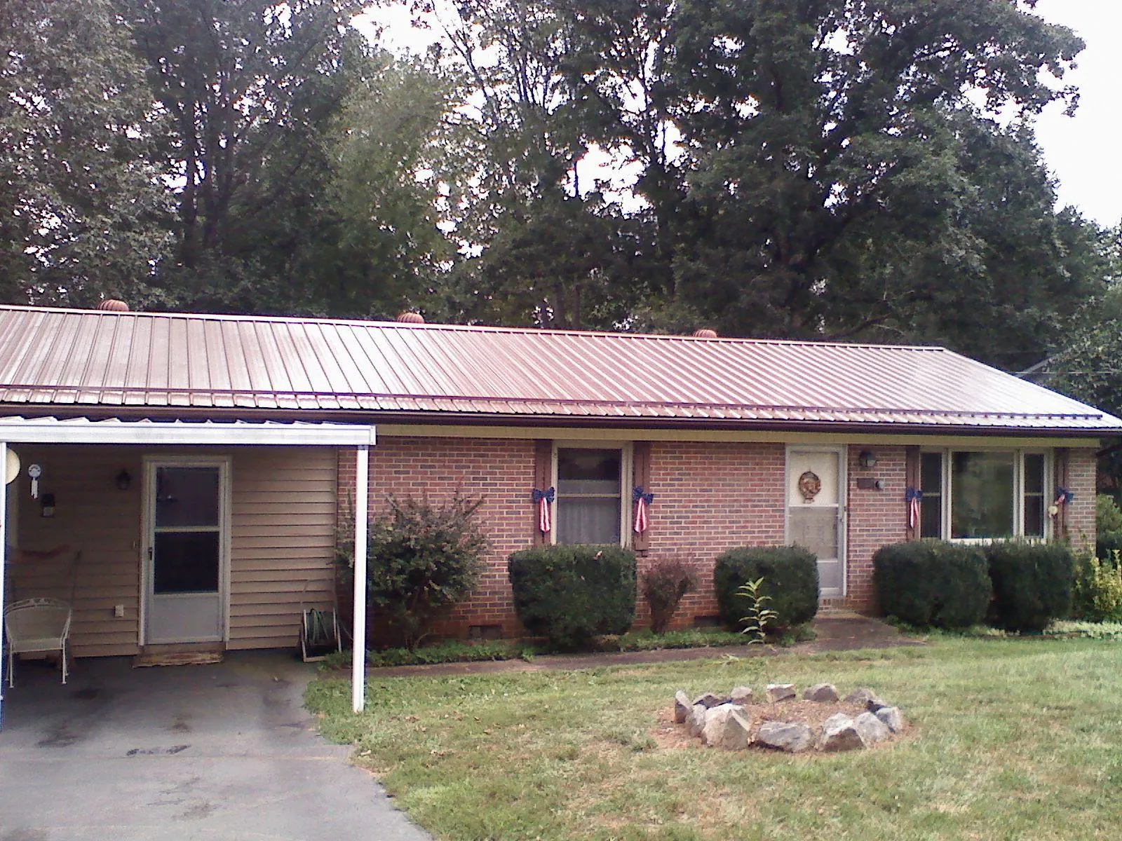 Bronze metal roof and carport on a brick ranch home — Roof Repair work by our crew in Baconton